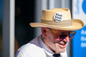 Person in a straw hat with a button that says "Blah blah blah"